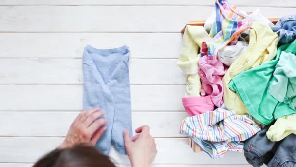 Marie Kondo escribiendo el concepto de método - doblar la ropa de los niños — Vídeo de stock