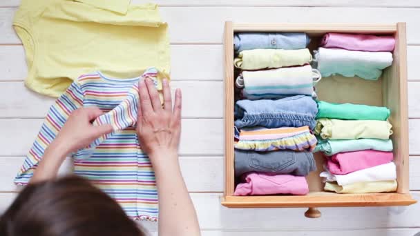 Marie Kondo escribiendo el concepto de método - doblar la ropa de los niños — Vídeo de stock