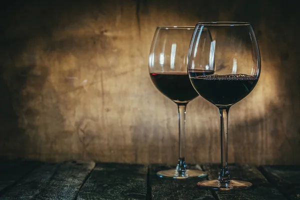 Красное и белое вино в стаканах на деревенском фоне — стоковое фото