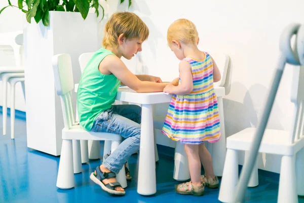 Bambini che giocano e disegnano nel tavolo dei bambini, angolo attività — Foto Stock