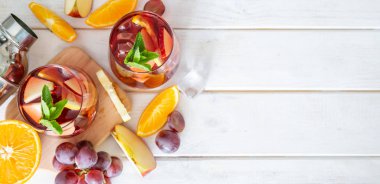 Sangria ve bardaktaki malzemeler ahşap arka planda.