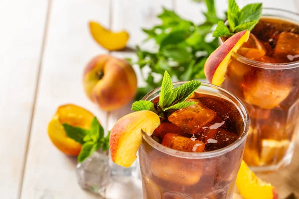 Chá gelado e ingredientes em óculos sobre fundo de madeira — Fotografia de Stock