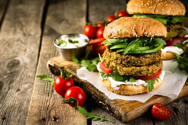 Vegan zucchini burger and ingredients on rustic wood background — Stock Photo, Image