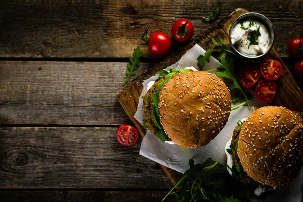 Vegan zucchini burger and ingredients on rustic wood background — Stock Photo, Image