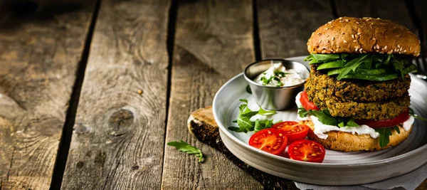 Vegan zucchini burger and ingredients on rustic wood background — Stock Photo, Image