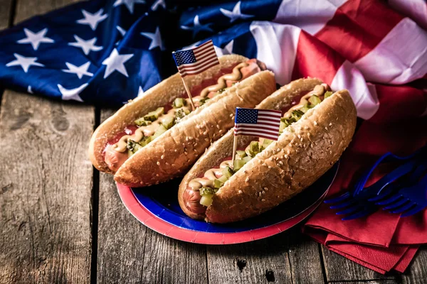 Día Nacional del Trabajo, Día de los Caídos, Día de la Bandera, 4 de julio - perros calientes con salsa de tomate y mostaza sobre fondo de madera —  Fotos de Stock