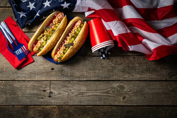 Día Nacional del Trabajo, Día de los Caídos, Día de la Bandera, 4 de julio - perros calientes con salsa de tomate y mostaza sobre fondo de madera — Foto de Stock