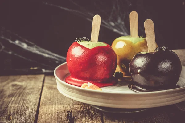 Dulces estilo Halloween - manzanas envenenadas negras, rojas y naranjas de caramelo — Foto de Stock