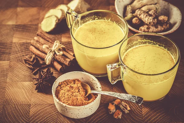 Куркума золотое молоко и ингредиенты на деревянном фоне — стоковое фото