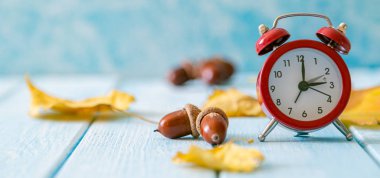 Sonbahar zaman değişimi kavramı - Ahşap zemin üzerinde kırmızı alarm saati