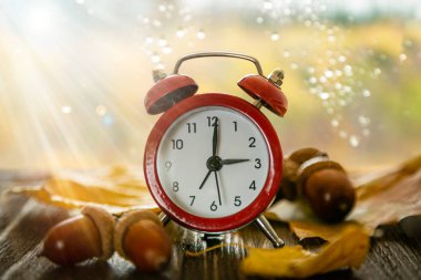 Sonbahar zaman değişimi kavramı - Ahşap zemin üzerinde kırmızı alarm saati