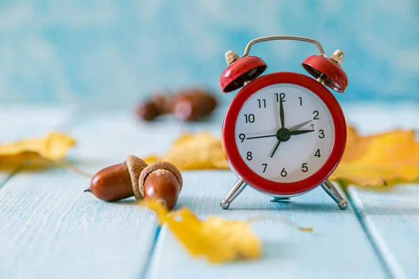 Herfst tijd verandering concept - rode wekker op hout achtergrond — Stockfoto