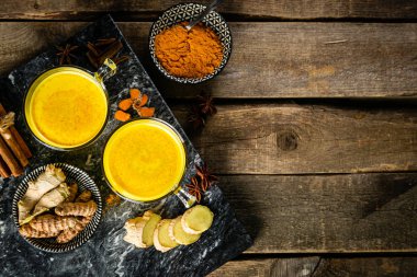 Zerdeçal altın sütü ve ahşap zemin üzerindeki malzemeler