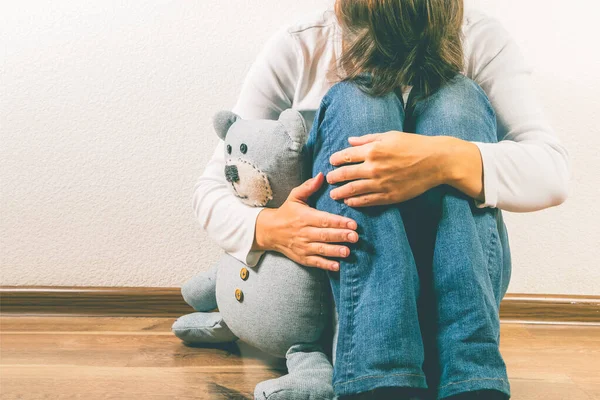 Концепция предродовой потери - депрессивная женщина с игрушкой плюшевого медведя — стоковое фото