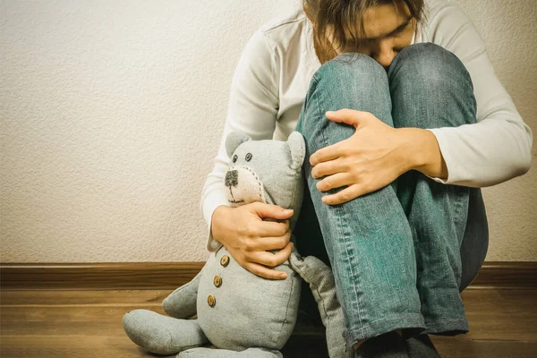Концепция предродовой потери - депрессивная женщина с игрушкой плюшевого медведя — стоковое фото