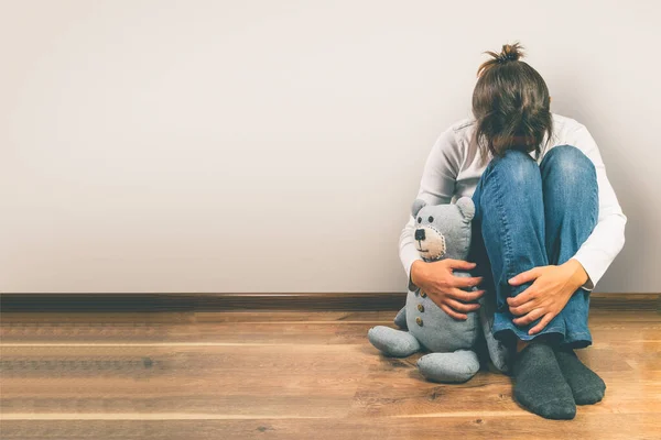 Концепція пренатальної втрати - пригнічена жінка тримає іграшку плюшевого ведмедя — стокове фото