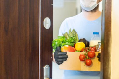 Güvenli yemek teslimatı konsepti - teslimatçı eldiven taşır