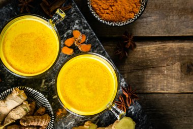 Zerdeçal altın sütü ve ahşap zemin üzerindeki malzemeler