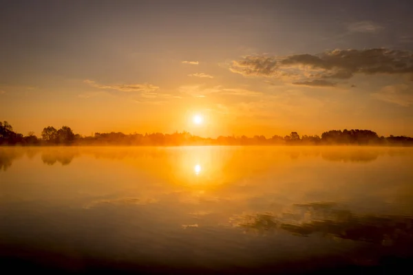 Восход солнца над прудом с облачным небом летом . — стоковое фото