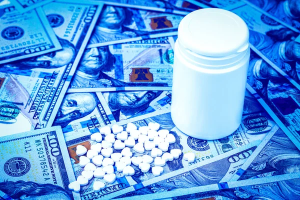100美元钞票背景下的心形药丸 昂贵的医疗或医疗融资成本的概念 白色药瓶 有文字复制空间 — 图库照片