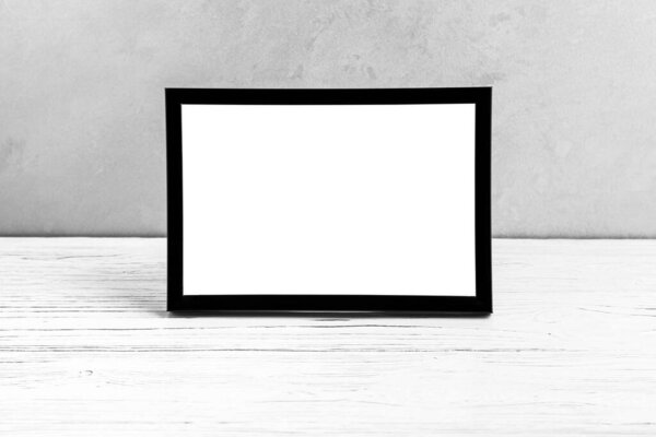 White wooden floor over concrete or decorative plaster wall and black photo frame with copy space for a text background. Mock up for design.