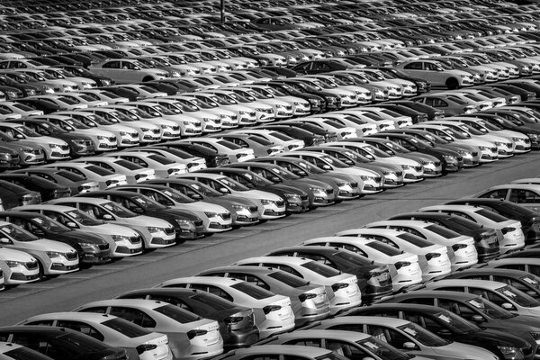 Volkswagen Group Rus, Russia, Kaluga - MAY 24, 2020: Rows of a new cars parked in a distribution center on a day in the spring, a car factory. Parking in the open air. Black and white photography.