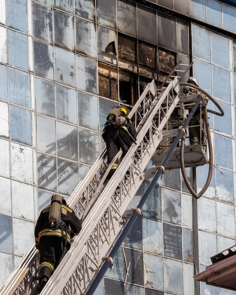 俄罗斯 卡卢加 2020年9月8日 一队身穿防护服 头戴钢盔的消防员在楼梯上扑灭了一幢窗户和屋顶被打破的大楼中的火灾 — 图库照片