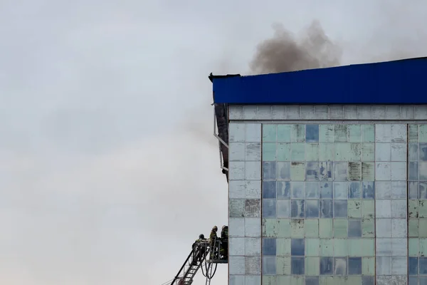 俄罗斯 卡卢加 2020年9月8日 一队身穿防护服 头戴钢盔的消防员在楼梯上扑灭了一幢窗户和屋顶被打破的大楼中的火灾 — 图库照片