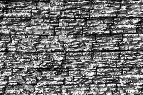 Black and white texture of a wall covered with decorative brick-like tiles. Abstract monochrome background for design.