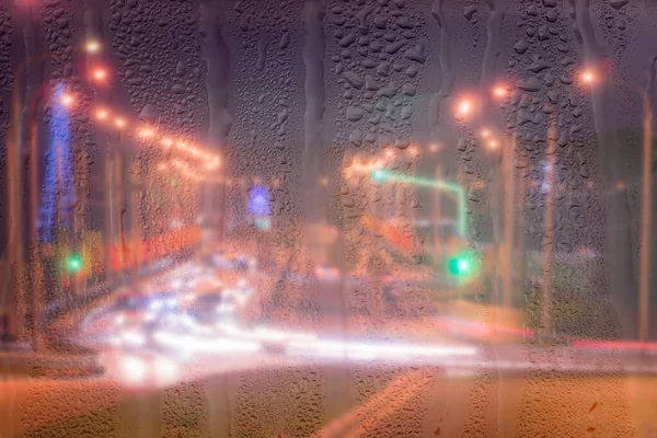 Rozostřené Reflektory Pohybujících Aut Deštivým Mokrým Sklem Noci Abstraktní Koncepce — Stock fotografie