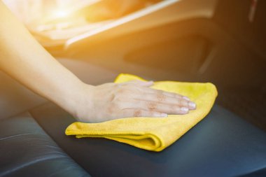 El sarı mikrofiber bezle deri oto koltuk Temizleme