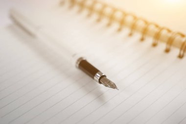 seçici odak üstünde açık beyaz defter kalem 