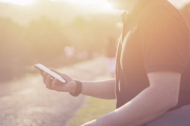 Smartphone parkta elinde tutan adam