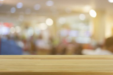 Boş kahverengi ahşap masa ile kahve dükkanında bokeh ışıkları ile arka plan bulanıklık 