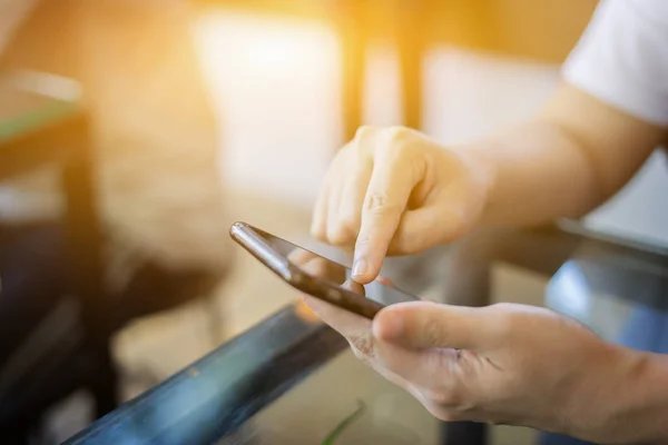 Man holding mobile phone and typing indoors