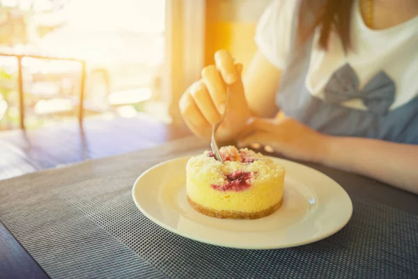 Kafede kaşıkla çilekli cheesecake yemek kadın