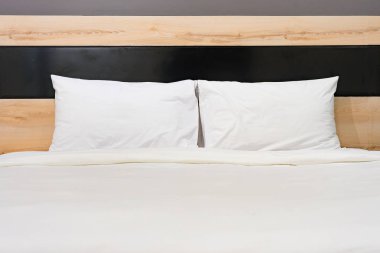 Yatak odasında büyük rahat çift kişilik yatak yumuşak ışık renkleri