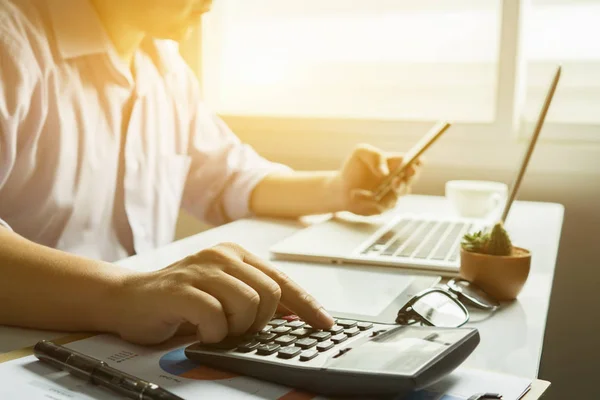 stock image Businessman working with calculator at table in office