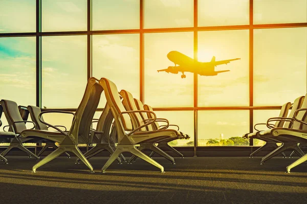 passenger seats in departure lounge and plane in airport