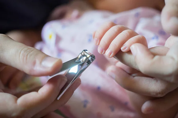 ピンセットを用いた新生児の手に母親切断釘 — ストック写真