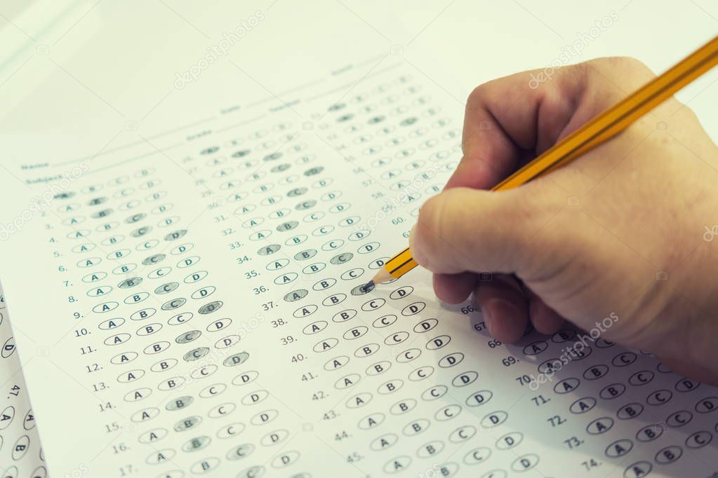 student finding right answers on test sheet with pencil