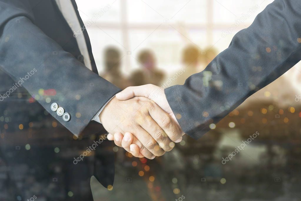 Double exposure of male handshake and city lights