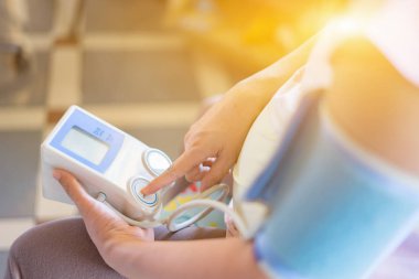 hamile kadının kolunda kan basıncı ölçer kullanarak kırpılmış görüntü