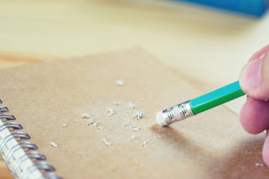 Adam bir kağıt parçasında yazılı bir hatayı ortadan kaldırıyor.