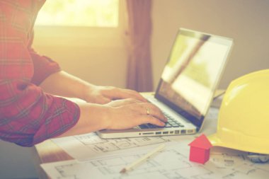 Laptop ve planları ile çalışan mimar adam