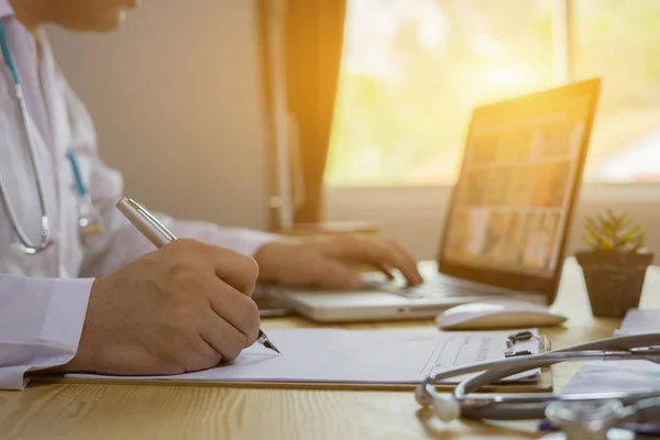 Medico Utilizzando Laptop Scrittura Con Penna Negli Appunti — Foto Stock