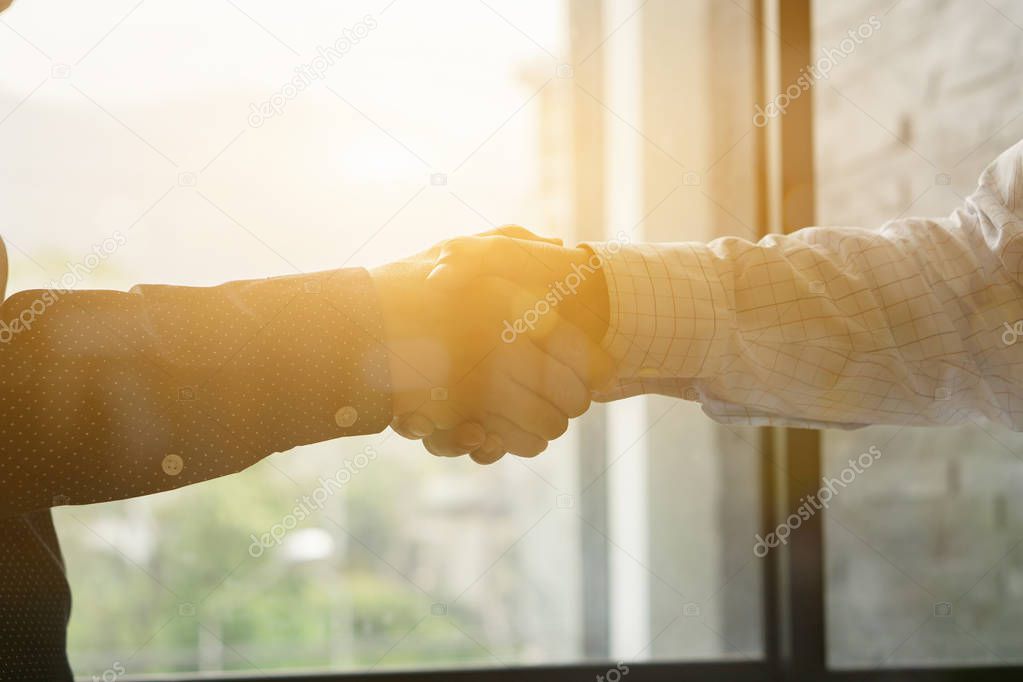 cropped image of businessmen shaking hands in office
