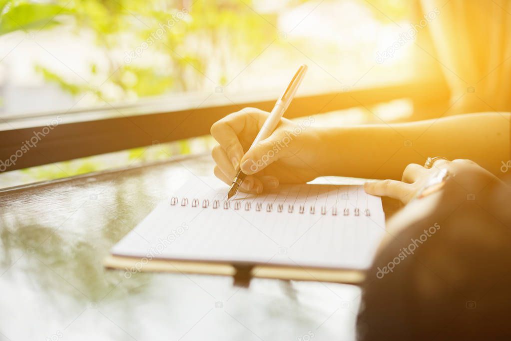 cropped image of woman writing in notebook