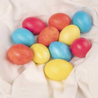 Masa örtüsü üzerinde çok renkli paskalya yumurtaları bir sürü