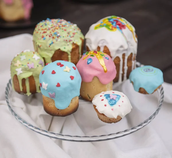 Decorated easter cakes with easter eggs on the special plate on the rustic table